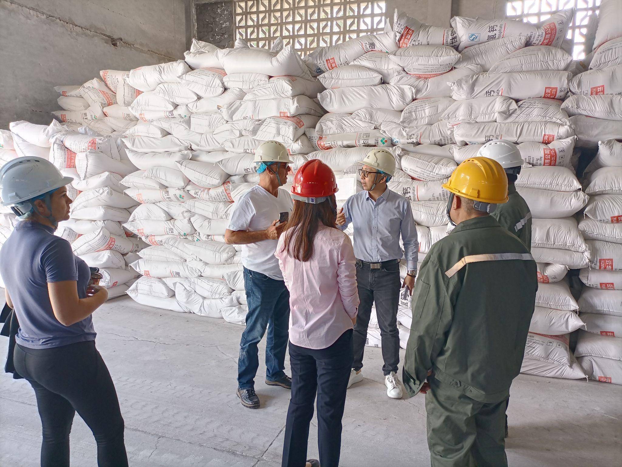Industrial team inspecting stored caustic soda bags in a warehouse