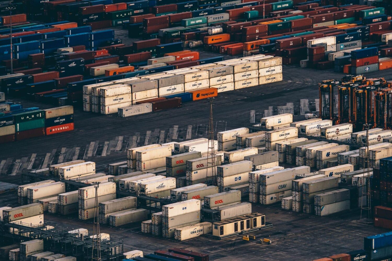 Rows of colorful shipping containers at an international cargo port, representing customs classification and chemical export logistics.