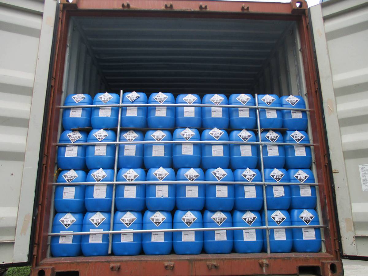  Blue plastic chemical drums labeled Phosphoric Acid 85% stacked neatly in a modern industrial warehouse.