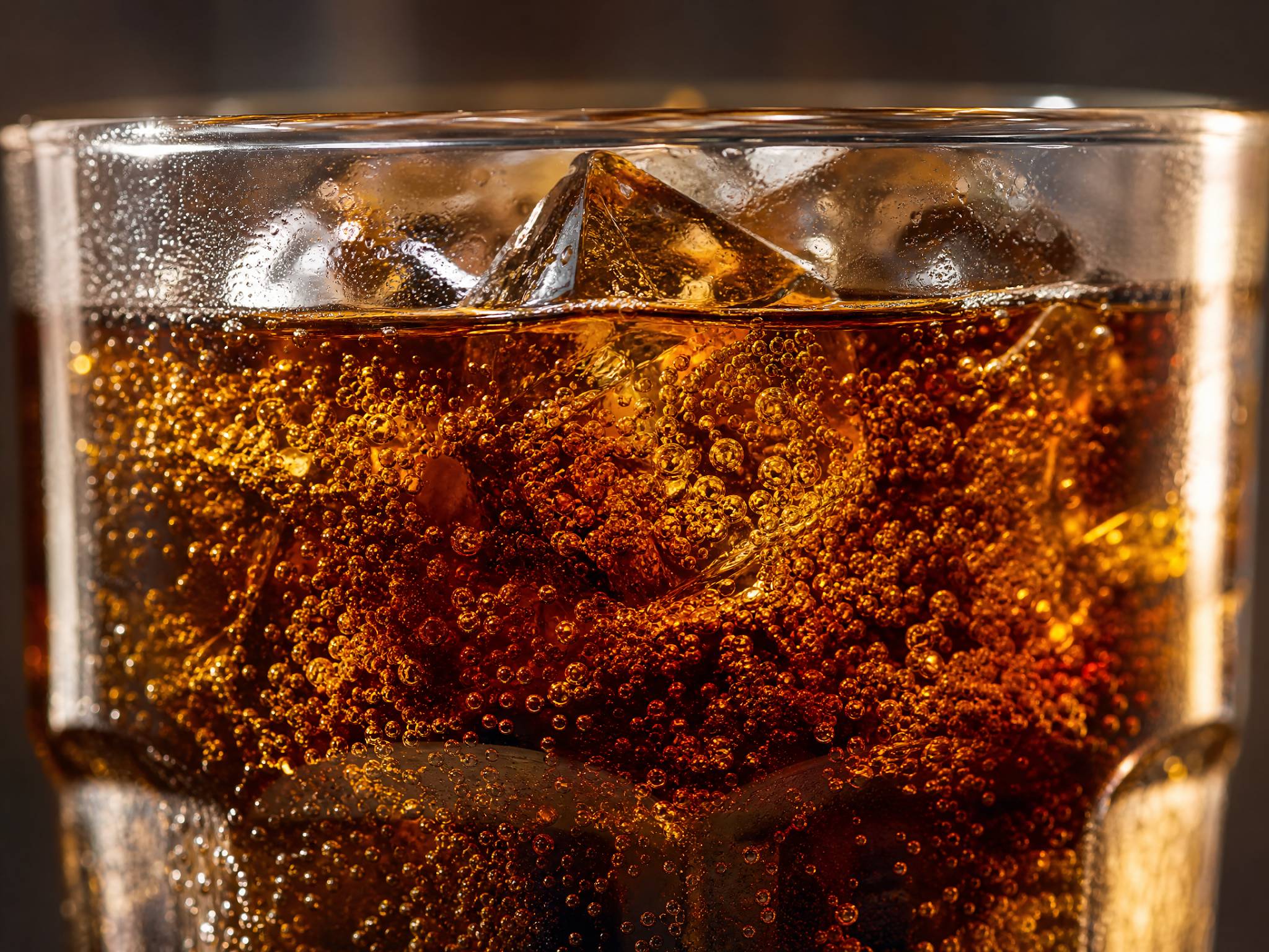 Phosphoric Acid in Food Industry and Food Additives 2 Close-up of a glass of dark cola with ice and effervescent bubbles.