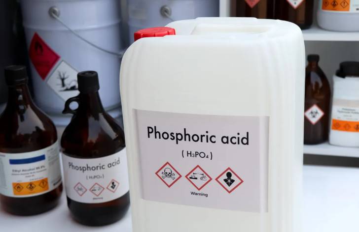 White plastic jerrycan with a prominent label reading Phosphoric Acid (H3PO4) and GHS hazard symbols alongside amber chemical reagent bottles