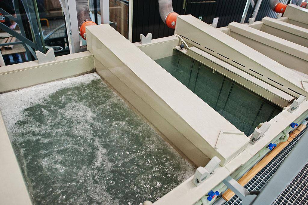 Industrial immersion tanks containing chemical bath solutions for metal treatment and electropolishing